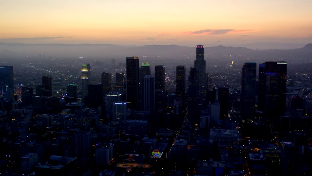 黄昏时洛杉矶市中心的鸟瞰图，向西望向海洋和好莱坞山，RED R3D 4K视频素材