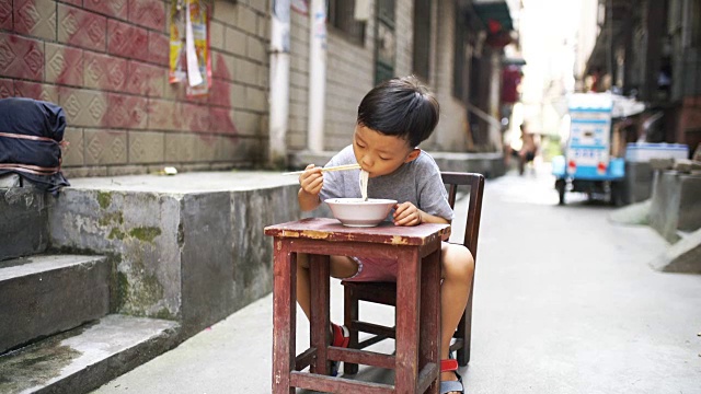 快乐的亚洲孩子用筷子吃美味的面条视频下载