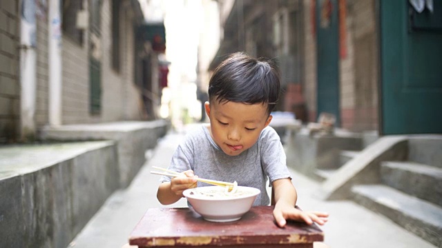 快乐的亚洲孩子用筷子吃美味的面条视频下载