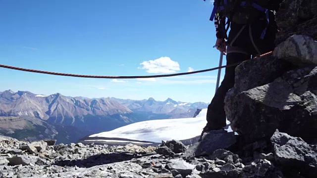 登山者横越冰封山脉之上的山脊视频素材