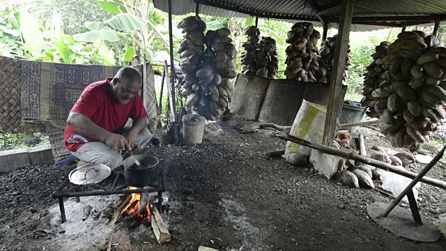 波纳佩密克罗尼西亚当地男子在他的小屋里用烟煮鸡肉视频素材