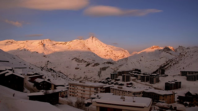 在Tignes的高山滑雪胜地，从一天到一夜的过渡与远处被雪覆盖的山峰视频素材