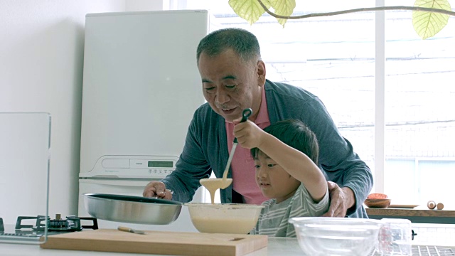 小男孩和他的爷爷一起做饭视频素材