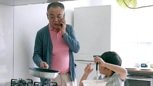 小男孩和他的爷爷一起做饭视频素材