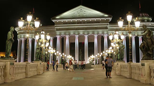 斯科普里，人们在国家考古博物馆前的文明桥上行走的夜景。视频素材