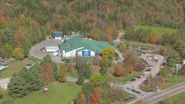 WS ZI AERIAL POV Ben & JerryÛ与秋天森林地区/沃特伯里，华盛顿县，佛蒙特州，美国的工厂视频素材