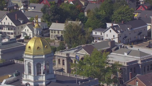 WS ZO AERIAL POV New Hampshire Flag and American Flag飘扬在New Hampshire State House, cityscape / Concord, New Hampshire, United States视频素材