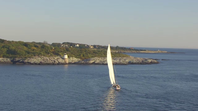 WS航空POV帆船移动在海湾和灯塔背景/纽波特，罗德岛，美国视频素材