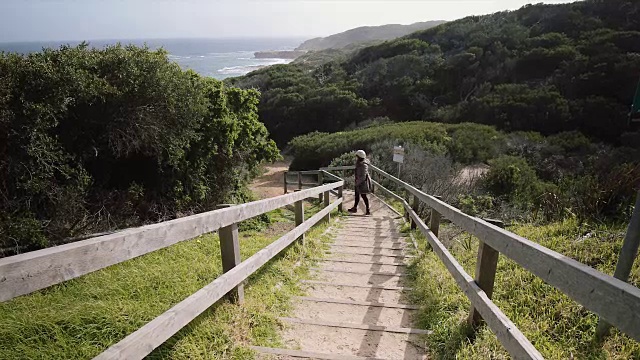 澳大利亚维多利亚州莫宁顿半岛，一名女子一边跳一边欣赏风景视频素材