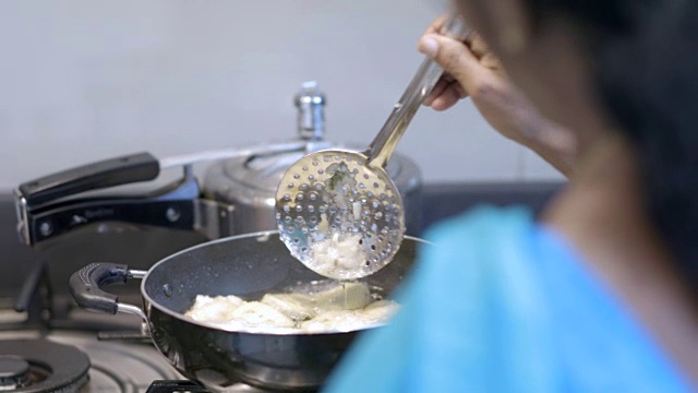 一名印度妇女在现代厨房里煮菜饭的照片视频素材