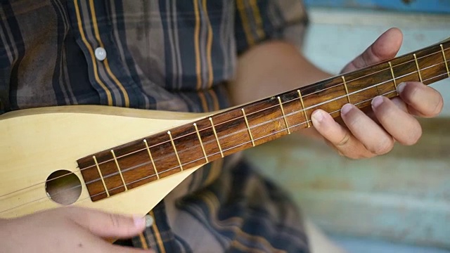 一位音乐家在古老的房子里弹奏曼陀林。视频素材