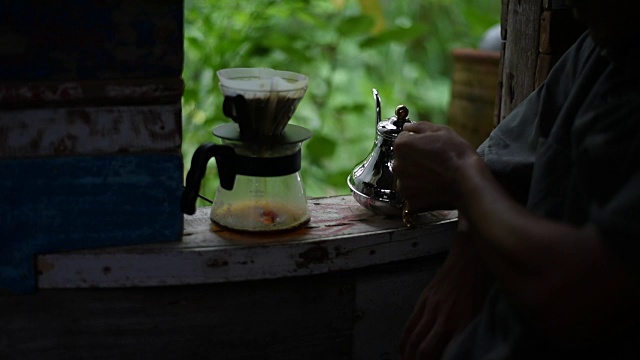 滴咖啡的过程，那个人把热水倒在地上的老式窗户上。视频素材