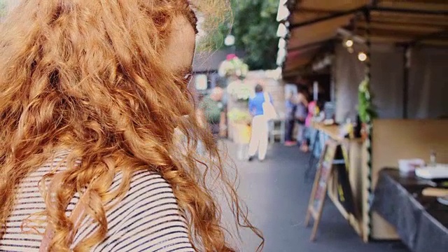 跟踪镜头跟踪年轻女子穿过市场视频素材