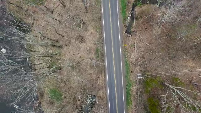 在纽约北部与河流平行的空的单车道道路的鸟瞰图视频素材