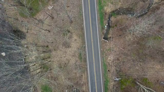 在纽约北部与河流平行的空的单车道道路的鸟瞰图视频素材