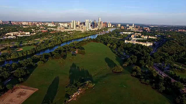 AERIAL:日落时分的Zilker公园，长长的阴影横跨令人惊叹的Austin Texas Park Over Grass field视频素材