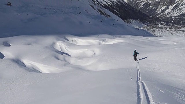 在冰川或群山环绕的新雪上滑雪视频素材