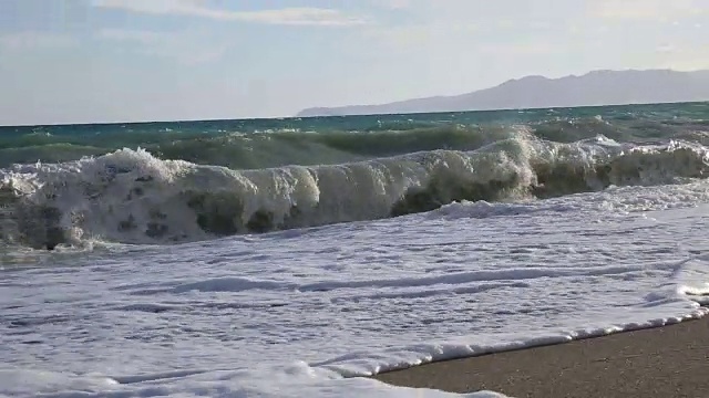 男人沿着海滩跑进海浪里视频素材