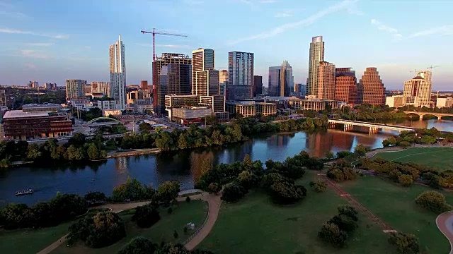 鸟瞰图:夕阳西下的德州山乡，小镇湖上的小船，德州奥斯汀市中心散发着金色的光芒视频素材