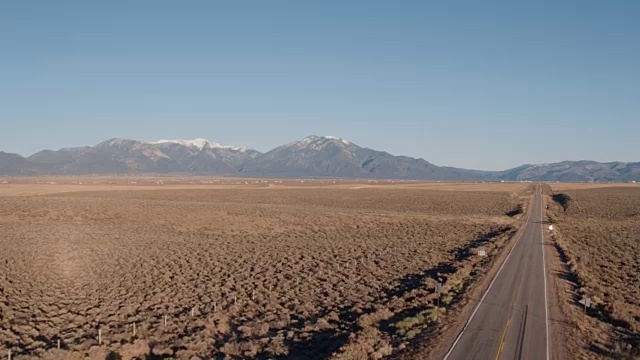 风景优美的汽车在沙漠公路上飞驰向群山视频素材