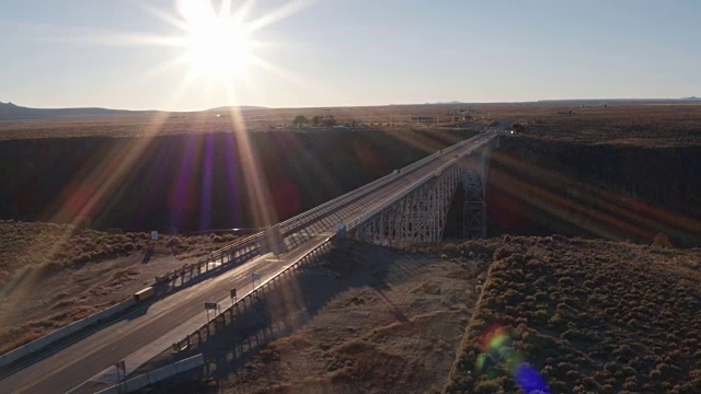 在阳光下飞过横跨峡谷的大桥视频素材