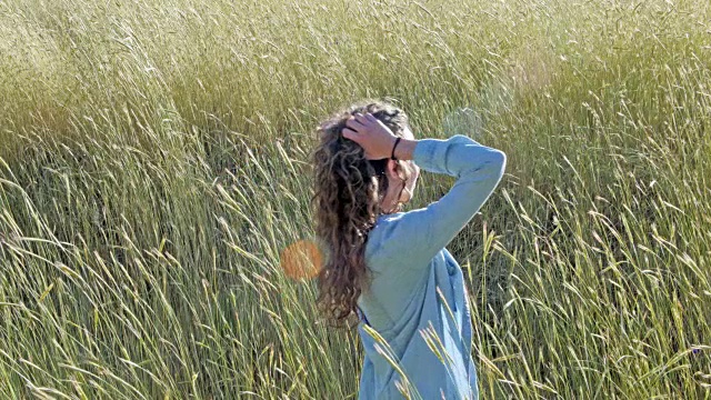 白人妇女在高草的田野转身视频素材