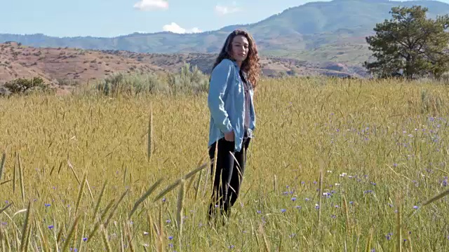 一个白人女人站在高高的草丛中视频素材