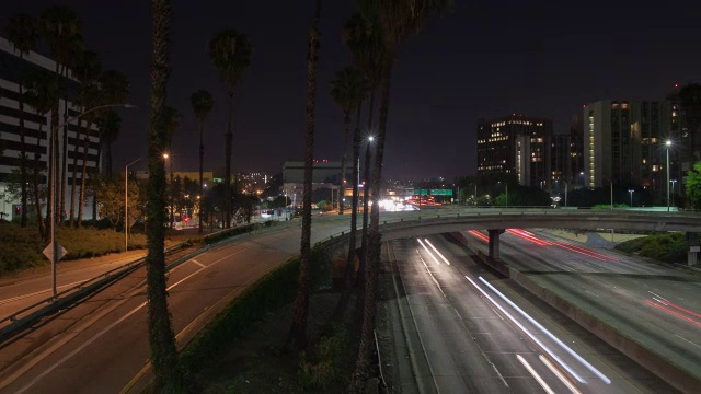 夜间在街道和桥上行驶的车辆，背景是摩天大楼视频素材