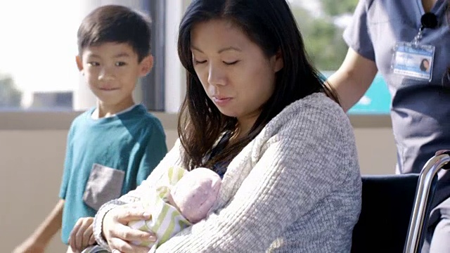 护士与家人在走廊推着新生儿母亲视频素材