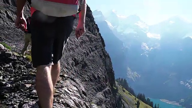 一群徒步旅行者攀登湖面上陡峭的山坡视频素材