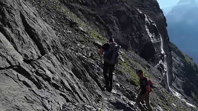 一群徒步旅行者攀登湖面上陡峭的山坡视频素材