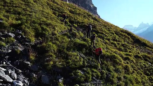 一群徒步旅行者攀登湖面上陡峭的山坡视频素材