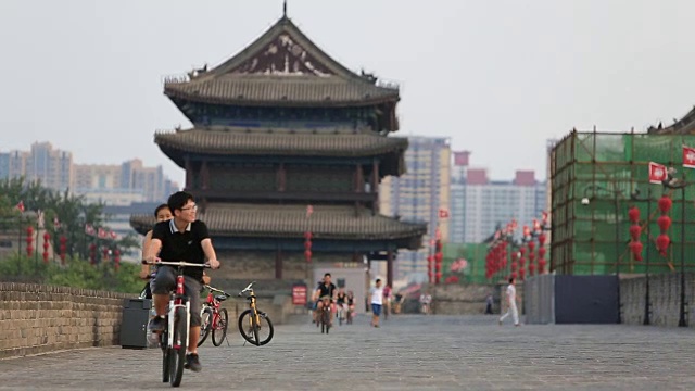 中国西安，2016年8月23日:游客在西安南门塔附近的古城上骑自行车视频素材