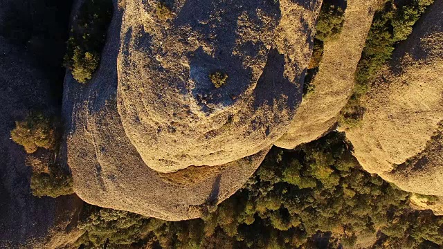 用无人机拍摄的航拍镜头记录了一个人徒步爬上山顶，在加泰罗尼亚比利牛斯山脉拍摄日落美景的同时，他还在沉思。4 k UHD。视频素材