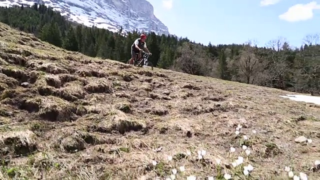 骑山地车的人沿着艾格尔脚下陡峭的山坡下山视频素材