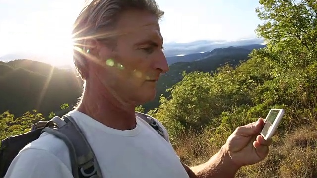 日出时，男性徒步者穿过草地，翻山越岭视频素材