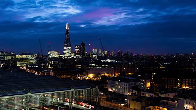 这是英国伦敦碎片大厦(Shard, UK)黎明时分的一段时间，随着天空从黑暗变为鲜艳的蓝色，周围建筑的灯光逐渐熄灭视频素材