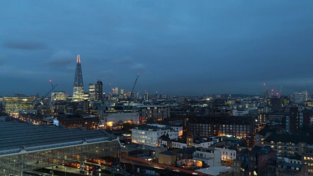 这是英国伦敦碎片大厦(Shard, UK)冬天从白天到夜晚的时间流逝，快速移动的云带着倾盆大雨穿过城市景观，随着夜幕的降临而褪去视频素材