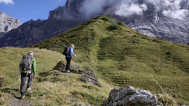 徒步夫妇横越高山山脊，望向群山视频素材