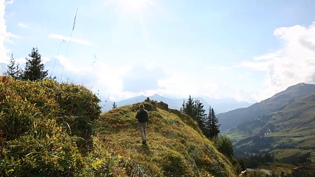 男性徒步者穿越高山山脊，越过遥远的山脉视频素材