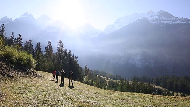 一群徒步旅行者攀登山地草地视频素材