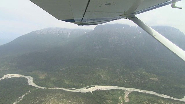 空中阿拉斯加山边和河流包括飞机机翼视频素材