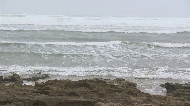 手持宽拍的海浪撞击岩石视频素材