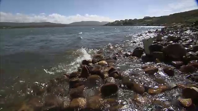 海浪涌上岩石海滩的特写镜头视频素材