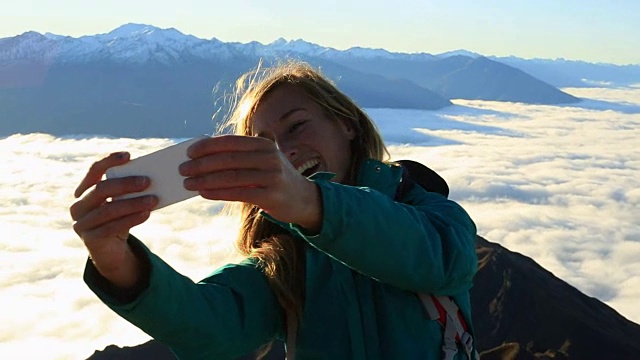 一名年轻女子在山顶自拍视频素材