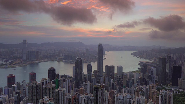 在中国香港的维多利亚山顶上，黎明的日出俯瞰城市天际线和维多利亚港视频素材