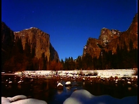 在优山美地山谷上方的天空中移动的时间流逝的星星与El Capitan白天到黄昏在冬天/水在前景/加利福尼亚视频素材