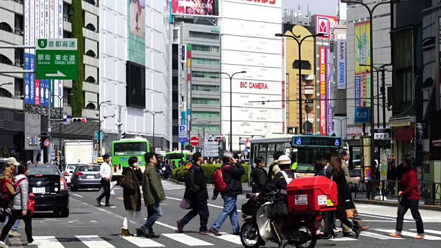 东京toshimaku Meiji-Dori ikebukuo站东入口前的摄像头捕捉到了行人和城市交通。视频素材