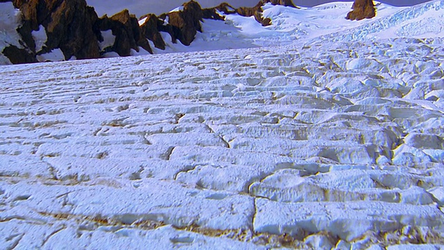 从光秃秃的山脉上空俯瞰冰雪覆盖的冰川/奥林匹克半岛的后方鸟瞰图视频素材