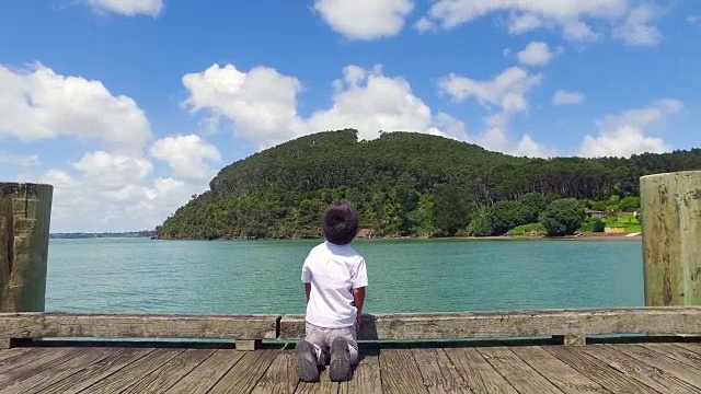 背靠天空站在海边的人的后视图视频素材